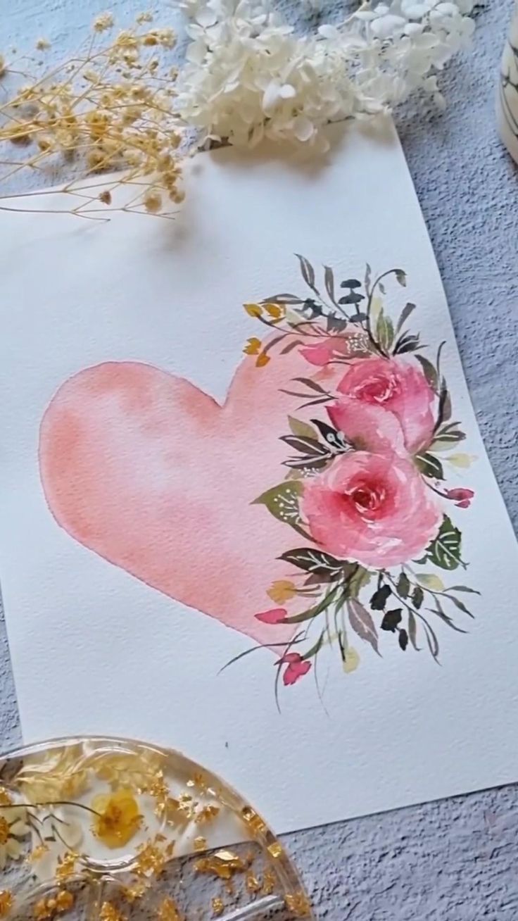 a piece of paper with flowers on it next to some scissors and other crafting supplies