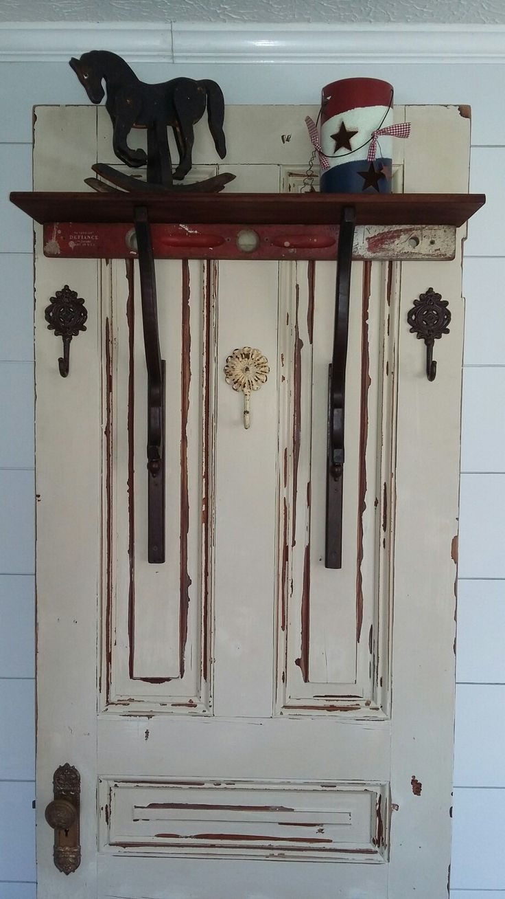 an old white door with two horse heads on the top and one in the bottom