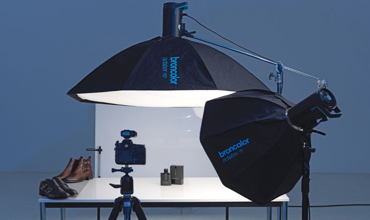 a person is sitting in front of a camera and some lighting equipment on a table