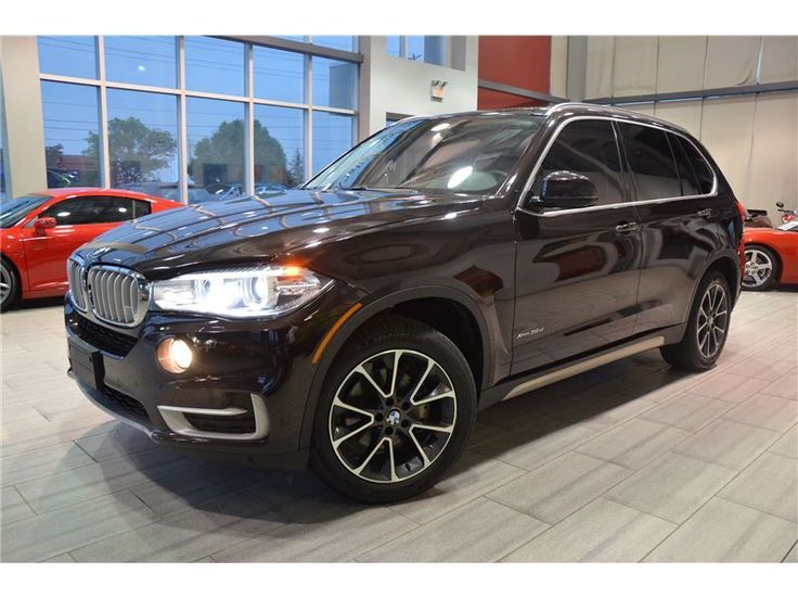 a black bmw suv is parked in a showroom