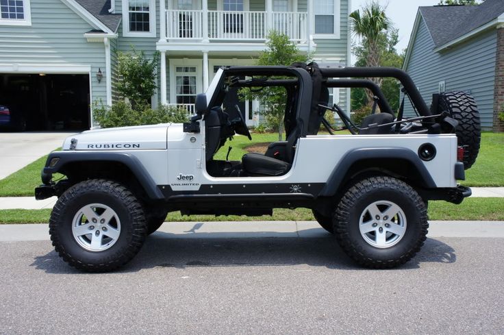 a white jeep parked in front of a house