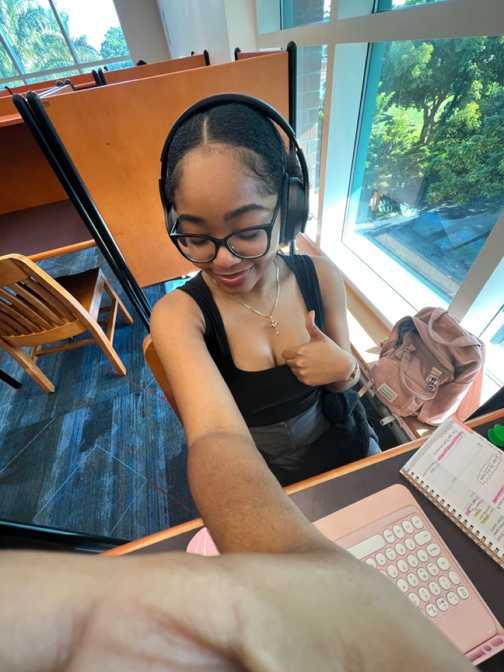 a woman wearing headphones sitting in front of a laptop computer