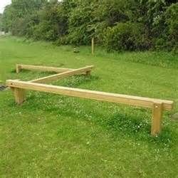 two wooden benches sitting on top of a lush green field with trees in the background