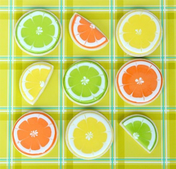 oranges, limes and lemon slices are arranged on a checkered tablecloth