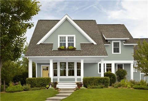 a blue house with white trim on the front door and steps leading up to it