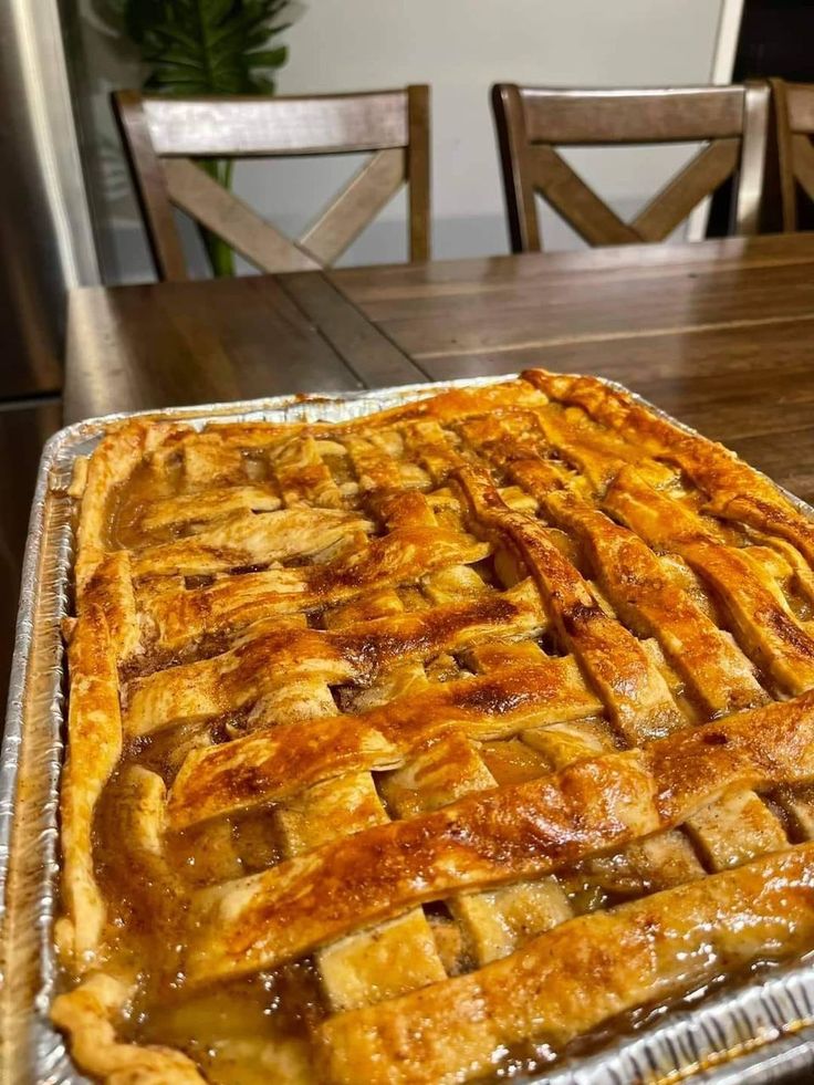 an apple pie sitting on top of a wooden table