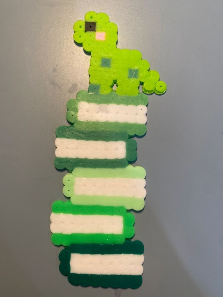 a green and white broccoli toy hanging from a wall