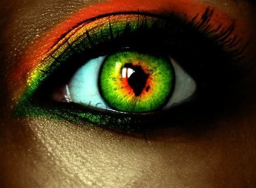 a woman's eye with bright green and orange colors on her iris, which is part of the image