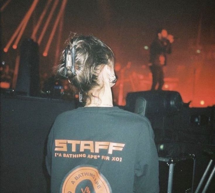 a young man wearing a star t - shirt standing in front of a stage