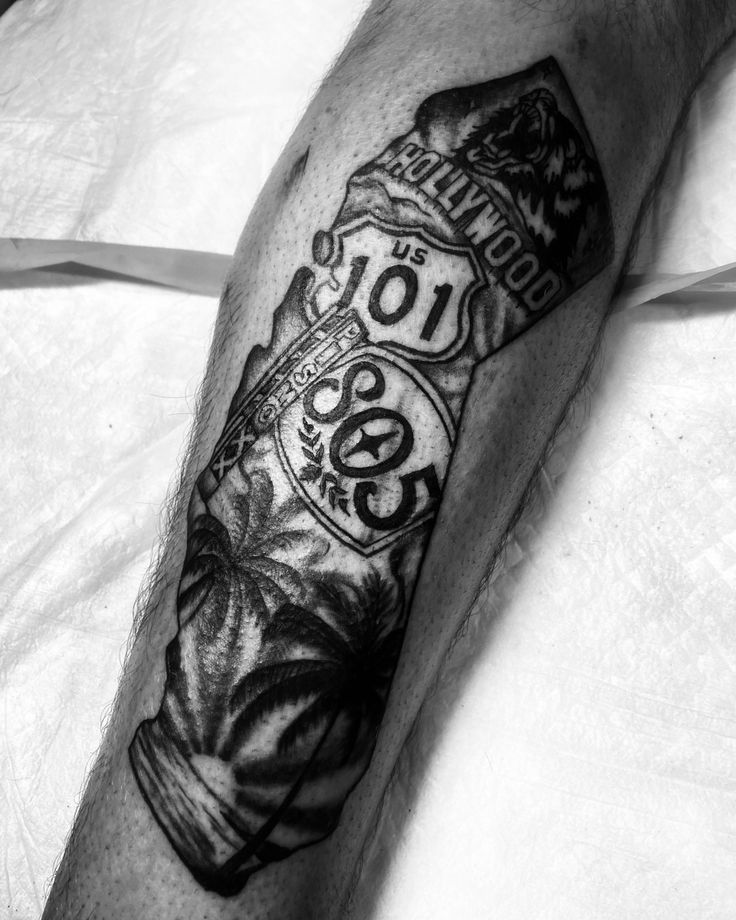 a black and white photo of a man's arm with tattoos on it