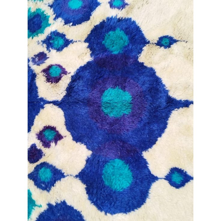 an area rug with blue and white designs on the ground, including circles in different colors