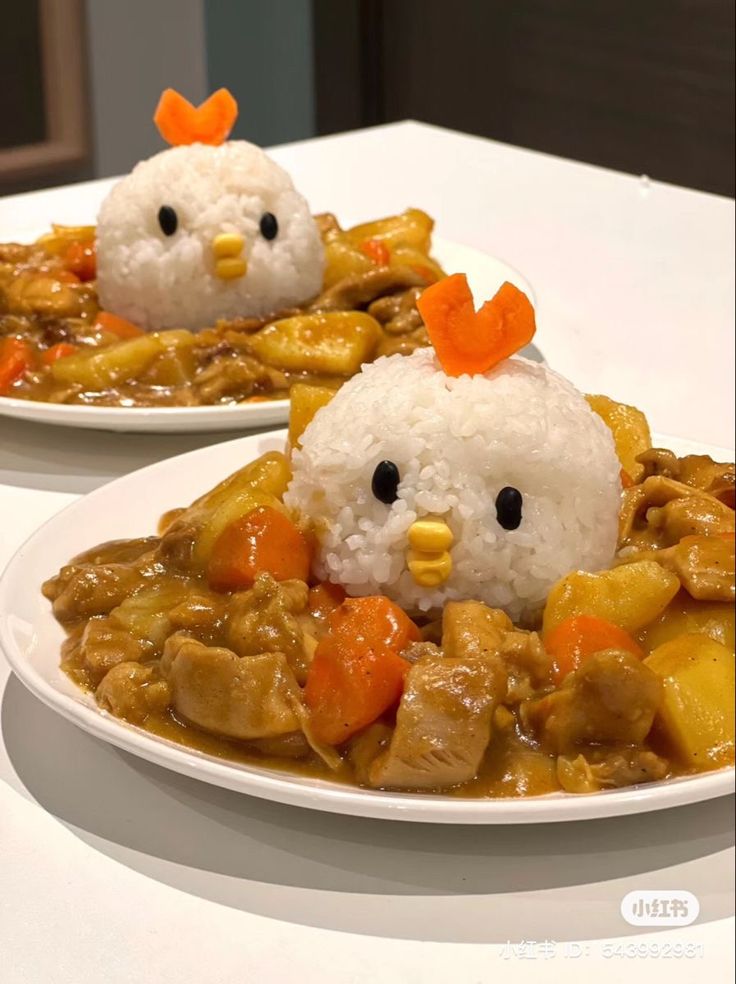 two white plates topped with rice covered in chicken and veggies next to each other