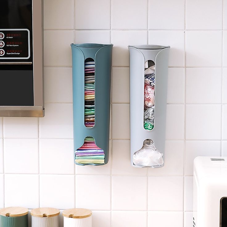 two kitchen utensils hanging on the wall next to a toaster and microwave