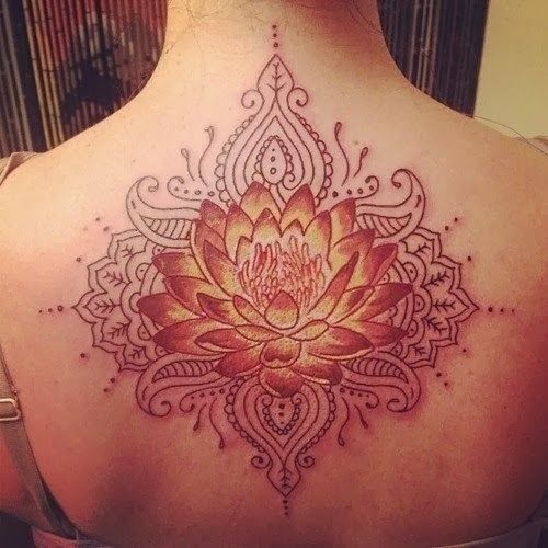 the back of a woman's neck with an intricate tattoo design on her chest