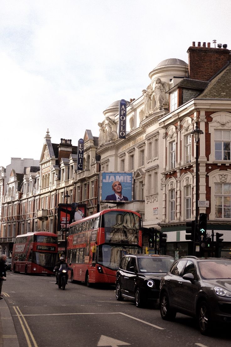 a double decker bus is driving down the street in front of some buildings and cars