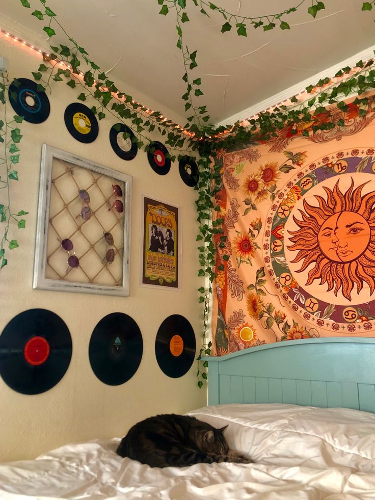 a cat laying on top of a bed under a blanket covered in vinyl record artwork