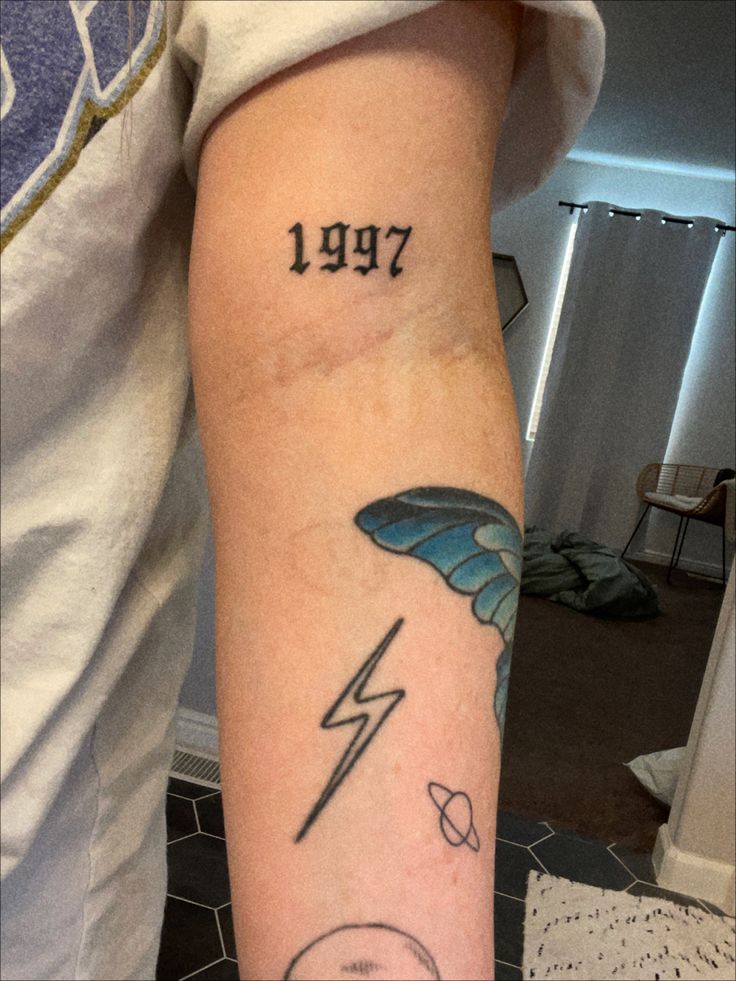 a person with a tattoo on their arm that has lightning and the word 1917 written in black ink