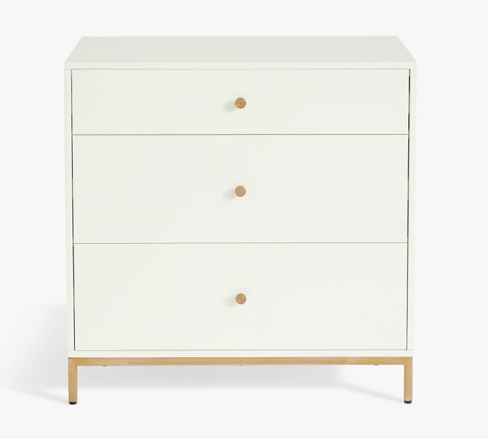 a white dresser with three drawers and gold handles