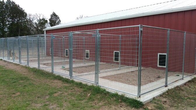 a red barn with a metal fence around it and a dog door on the side