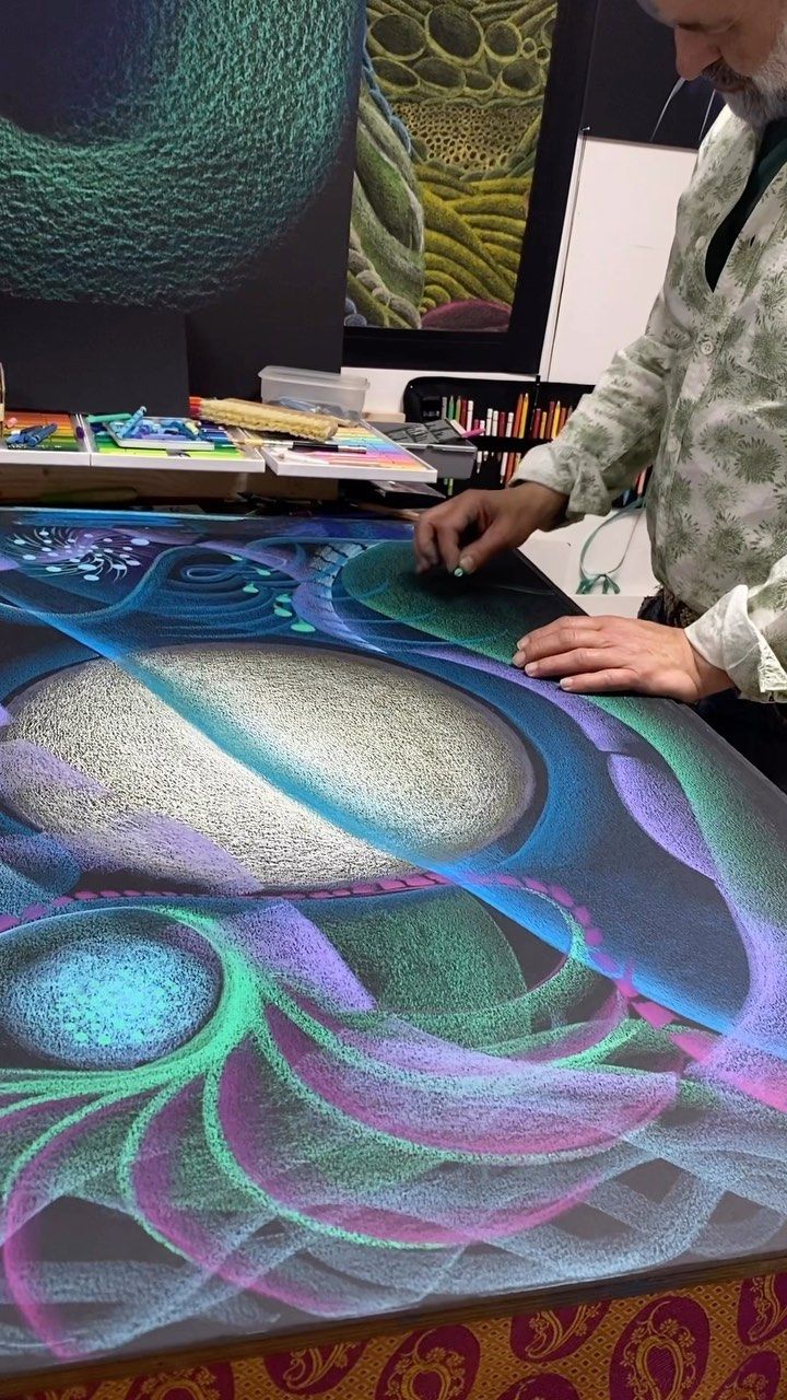 a man standing in front of a table with an art work on it