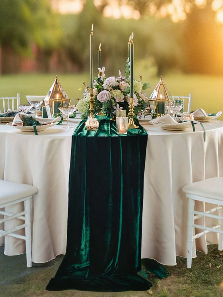 the table is set with candles, plates and napkins for an elegant dinner party