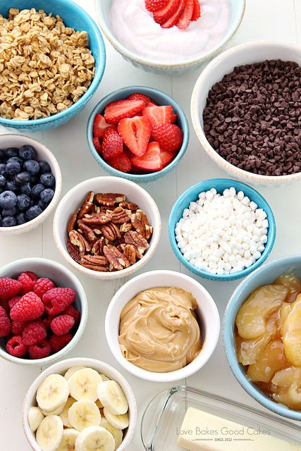 bowls filled with different types of fruit and cereals on top of a white table