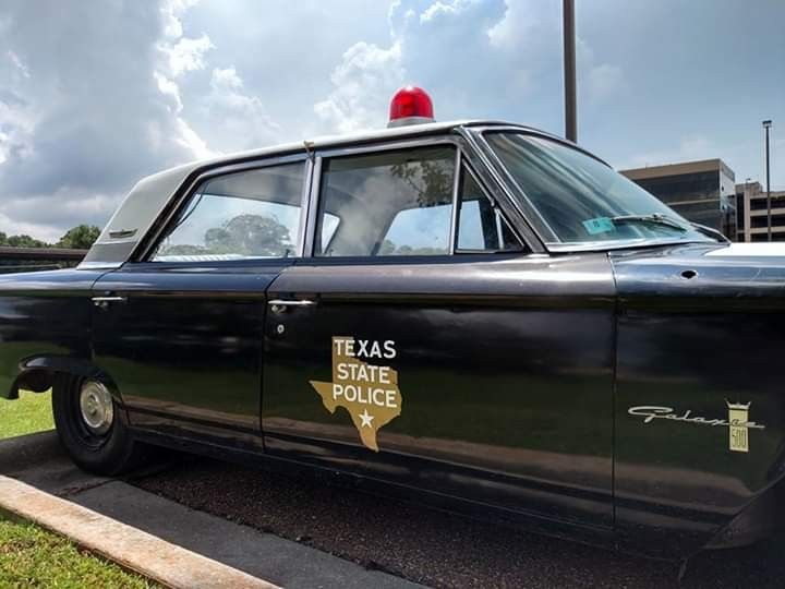 an old police car is parked on the side of the road