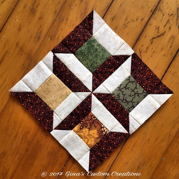 a close up of a piece of fabric on a wooden floor with a block in the middle