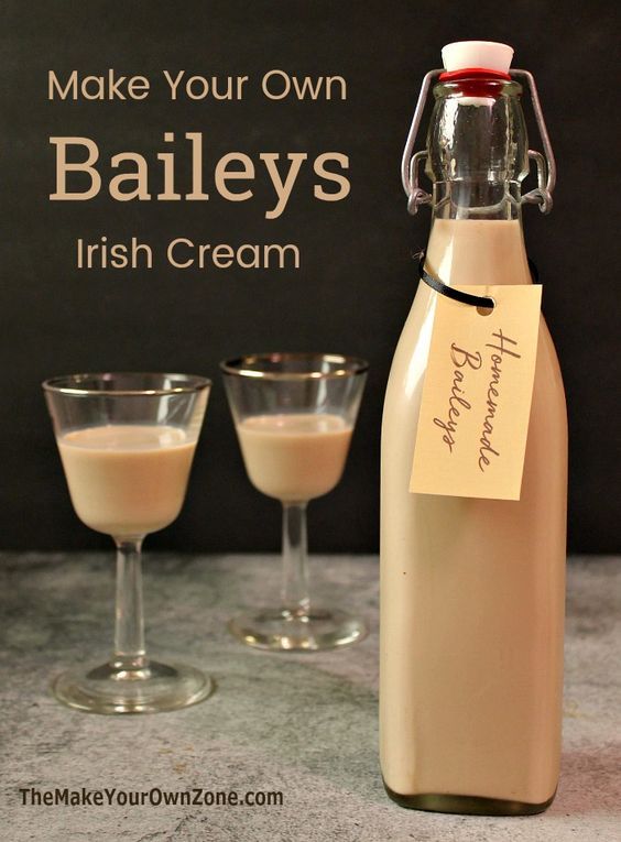 a bottle of bailey's irish cream next to two wine glasses and a sign that says make your own baileys irish cream