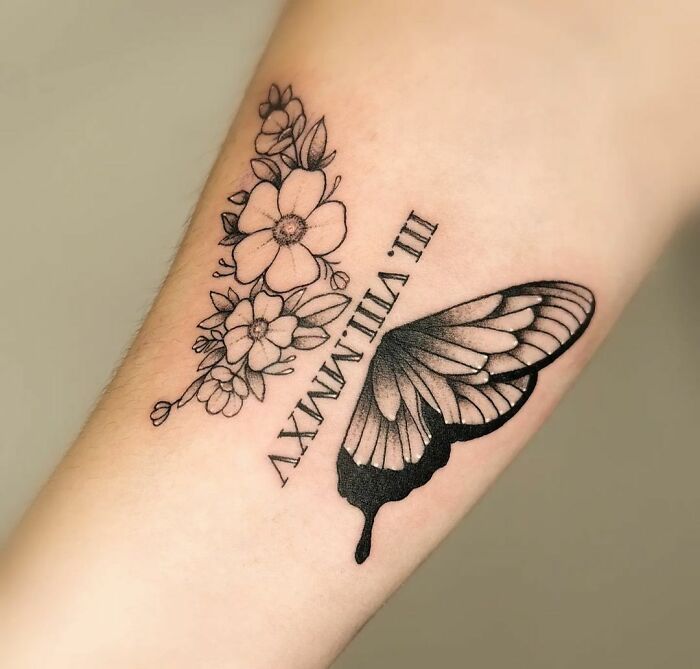 a black and white butterfly tattoo on the arm