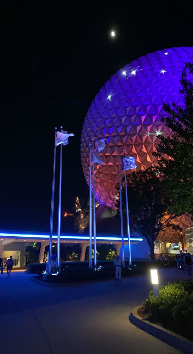 the spaceship shaped building is lit up at night