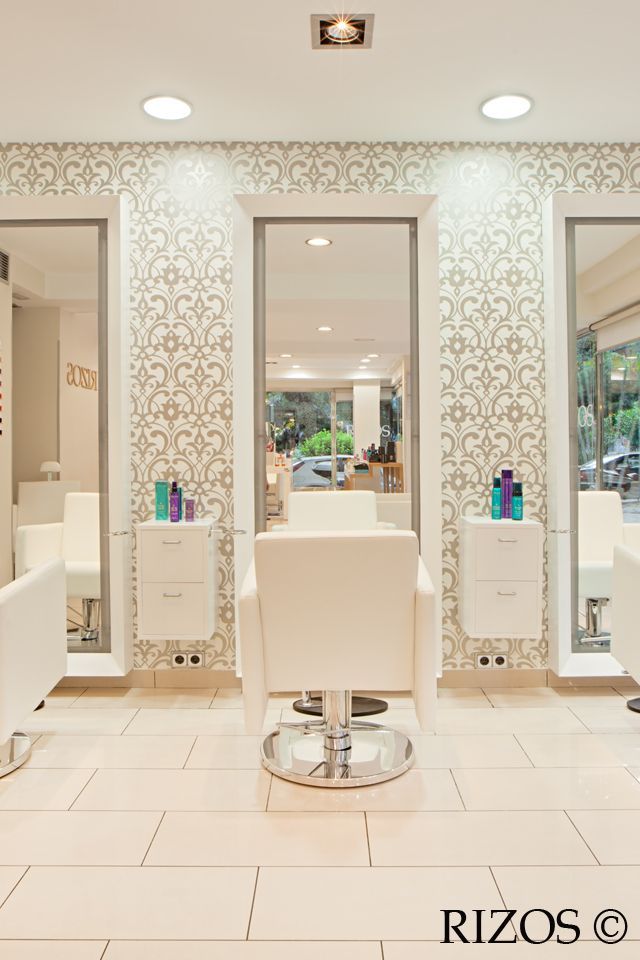 a hair salon with chairs and mirrors in the middle of the room, all white