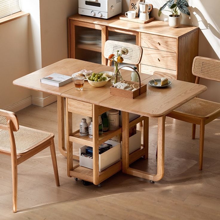 a wooden table with two chairs and a microwave oven on top of it in front of a window