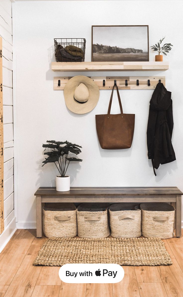 an entryway with baskets, coat rack and hat hanging on the wall above it