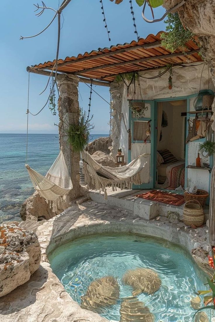 an outdoor hot tub with hammock hanging from the roof next to the ocean