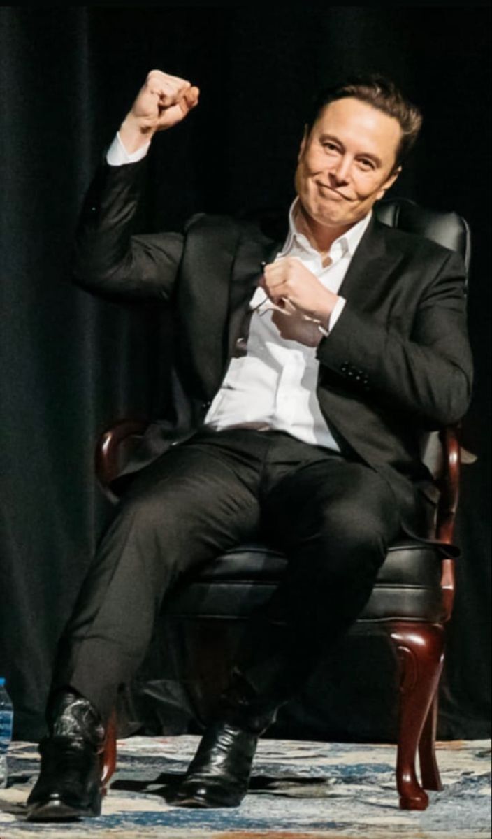 a man sitting in a chair raising his fist