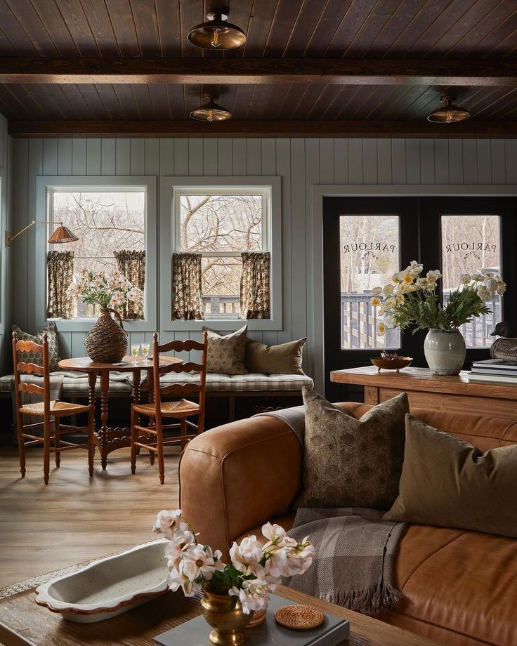 a living room filled with furniture and lots of windows next to a wooden floored wall