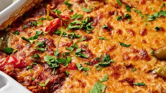 a casserole dish with tomatoes, peppers and parsley on the top is ready to be eaten