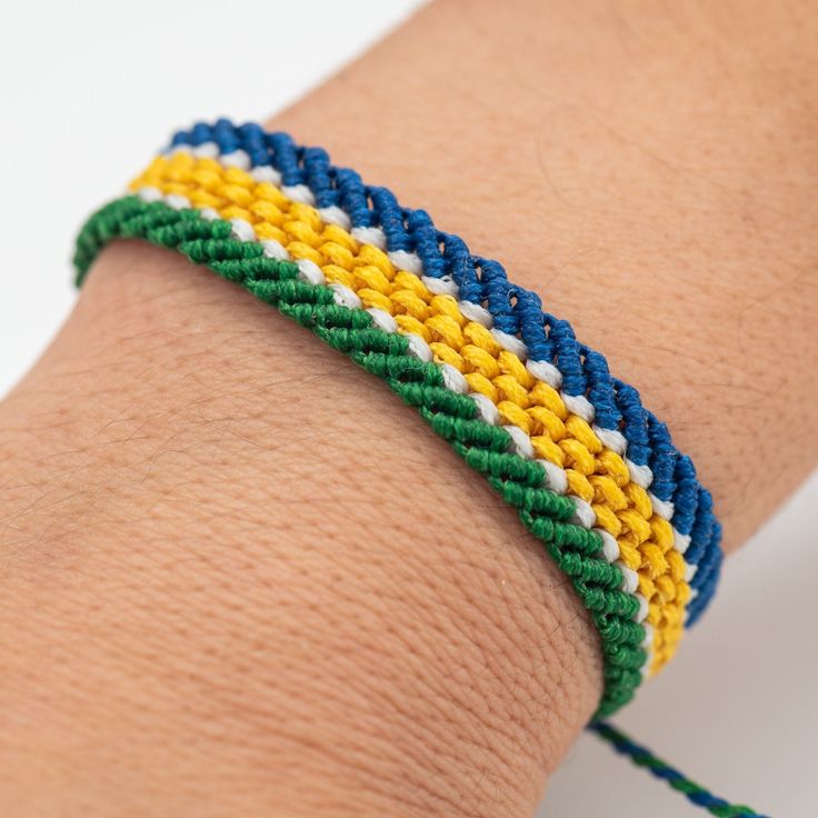 a close up of a person's arm wearing a bracelet with multicolored beads