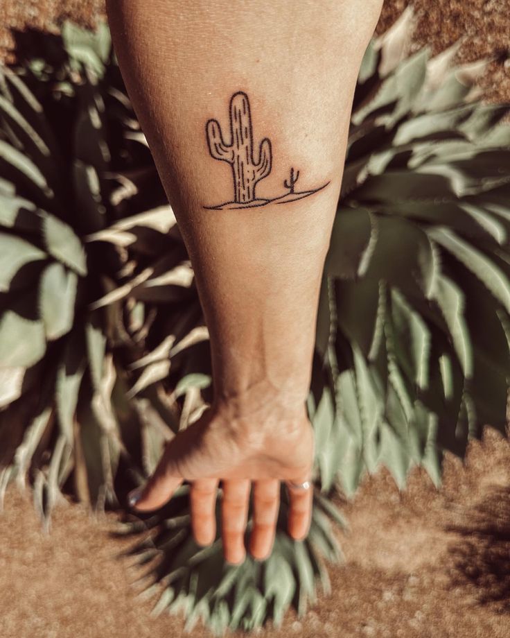 a person's foot with a small cactus tattoo on it