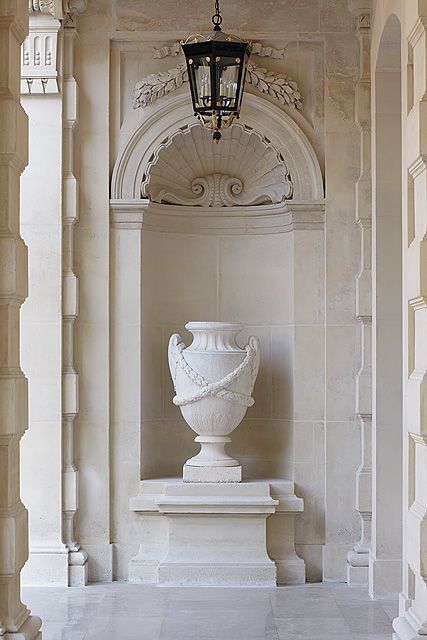 a large white urn sitting in the middle of a hallway