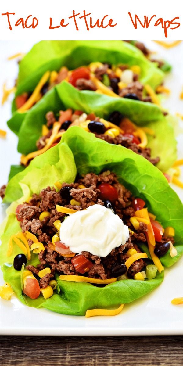 three lettuce wraps filled with ground beef, cheese and other toppings on a white plate