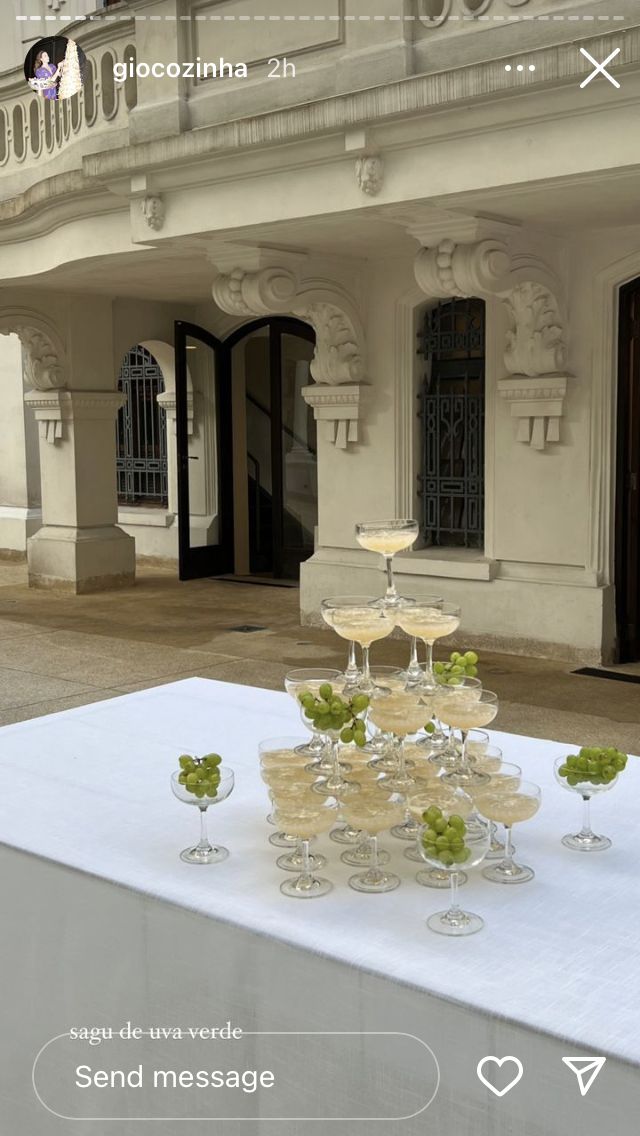 a table with wine glasses on it in front of a building