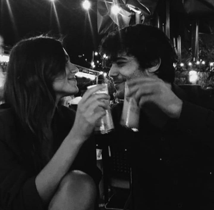 black and white photograph of two people drinking beer