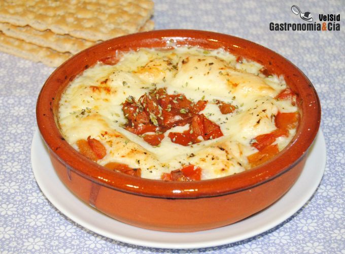 a bowl of food on a plate next to crackers