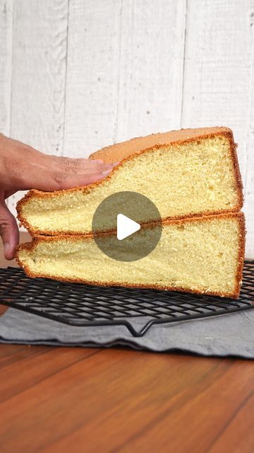 a person holding a piece of bread on top of a cooling rack