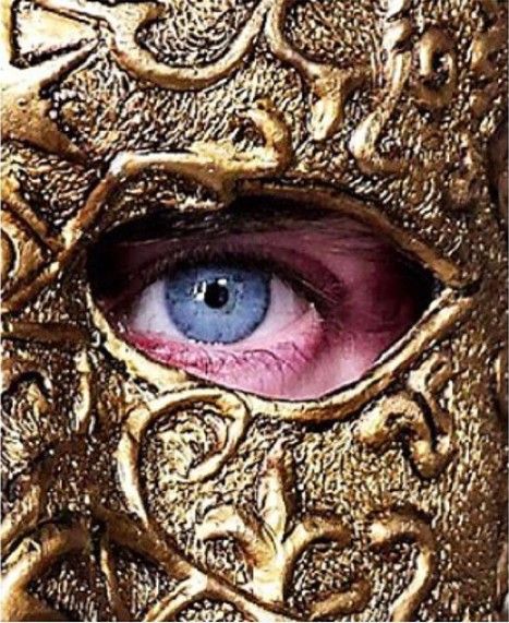 an eye that is in the middle of a gold mask