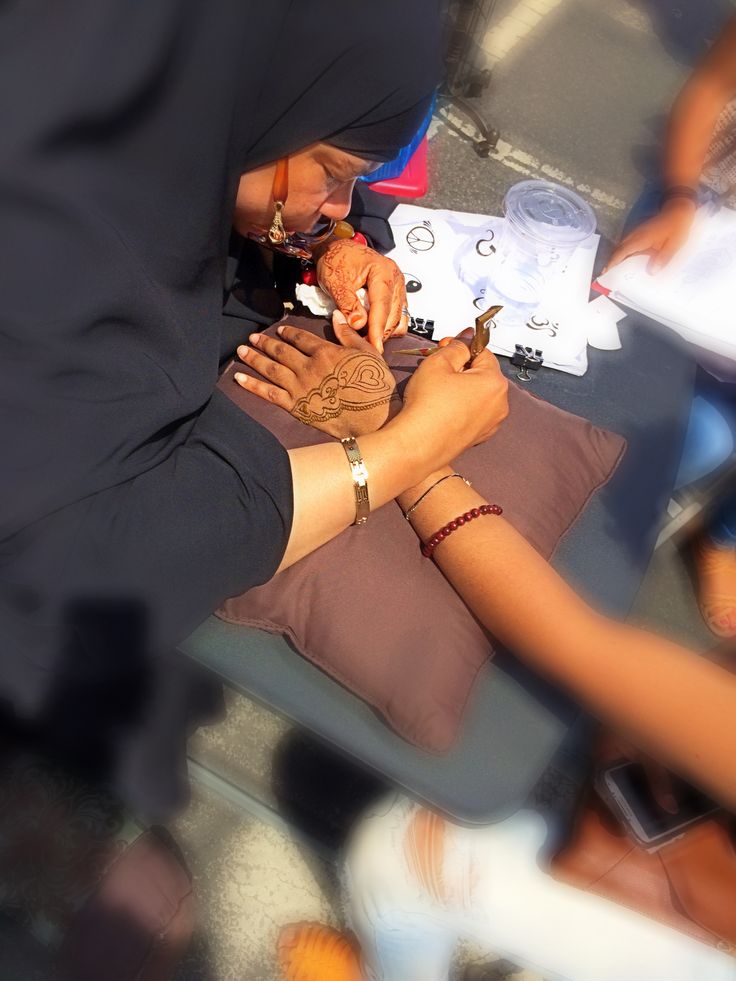 two people sitting at a table with papers and pens in their hands while another person writes