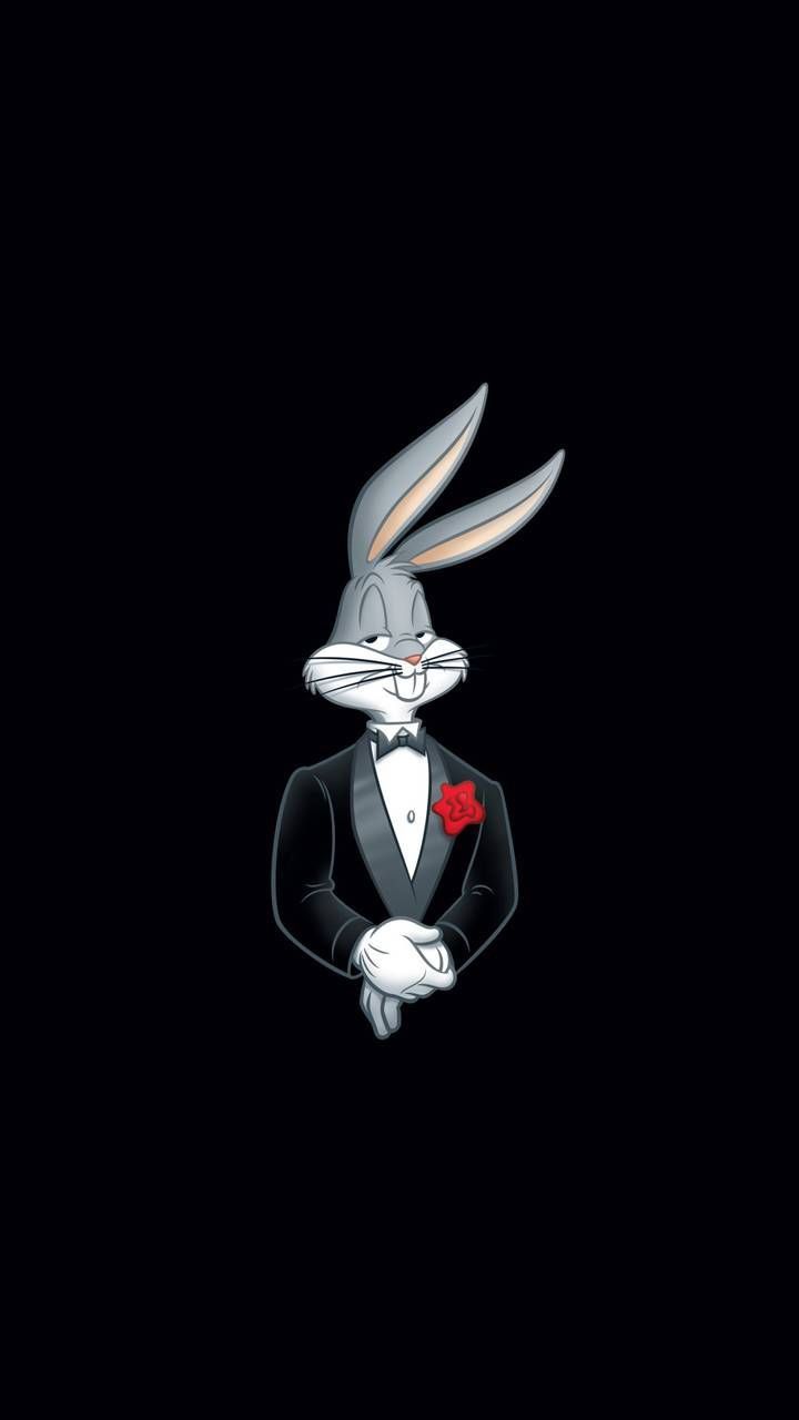 a rabbit in a tuxedo with a rose on his lap looking at the camera