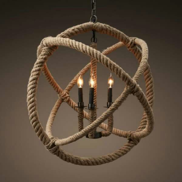 a chandelier made out of rope with three candles in the middle and one light on